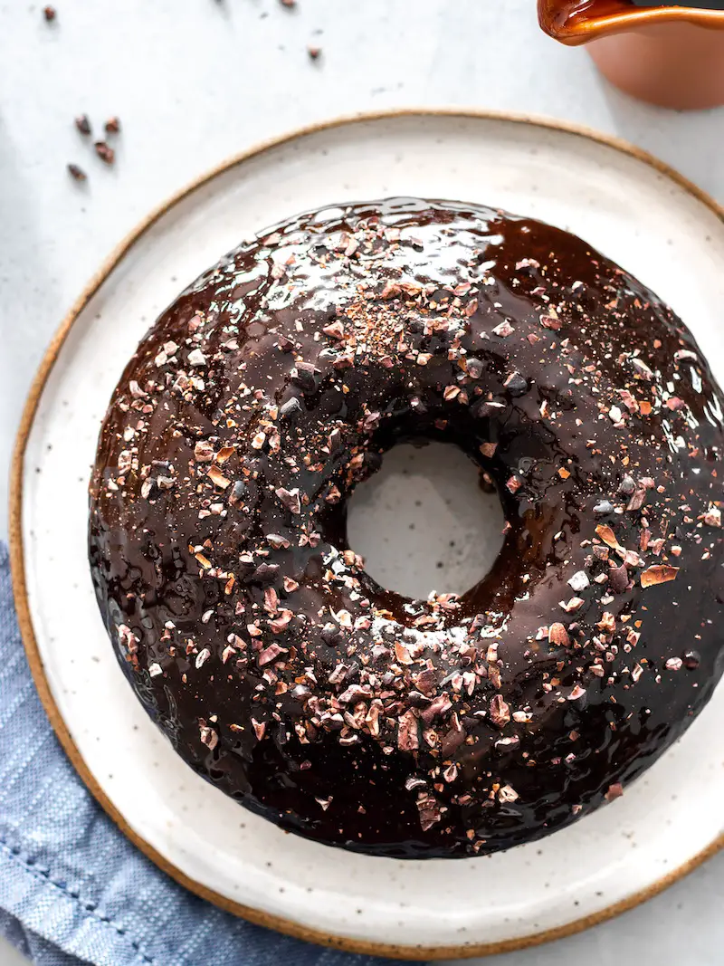 bolo de chocolate vegano simples e fofinho com calda de chocolate e nibs de cacau