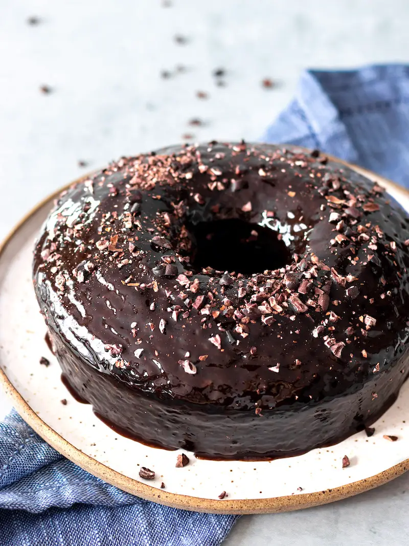 bolo de chocolate vegano simples e fofinho com calda de chocolate e nibs de cacau