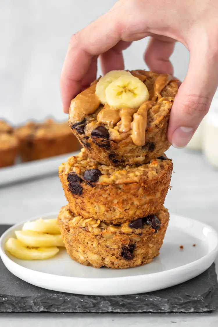 mão pegando um muffin de banana com aveia