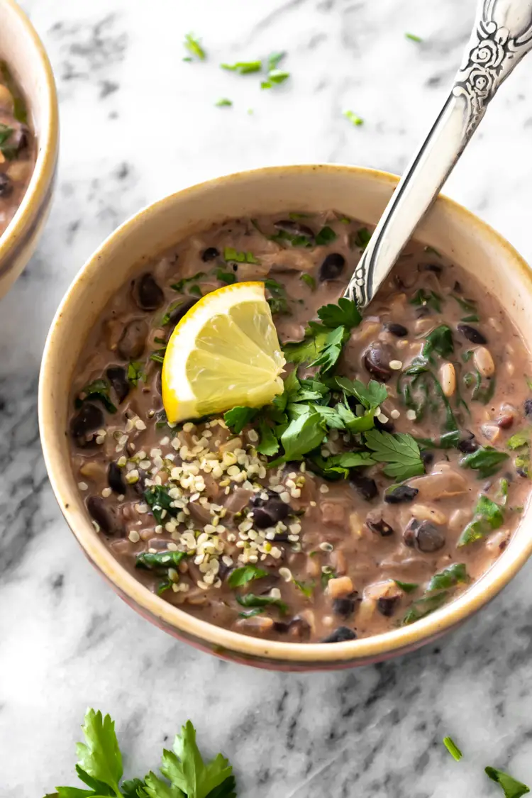 sopa de feijão com arroz e leite de coco servida com salsinha fresca picada e limão