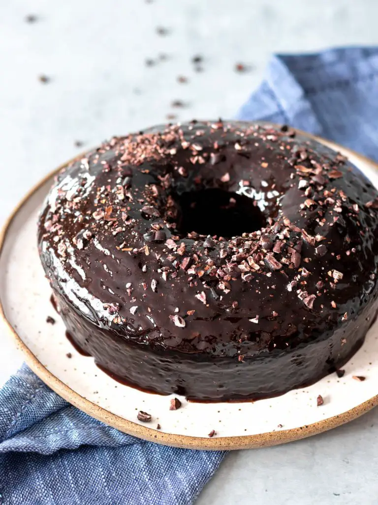 bolo de chocolate com calda brilhante de chocolate e nibs de cacau