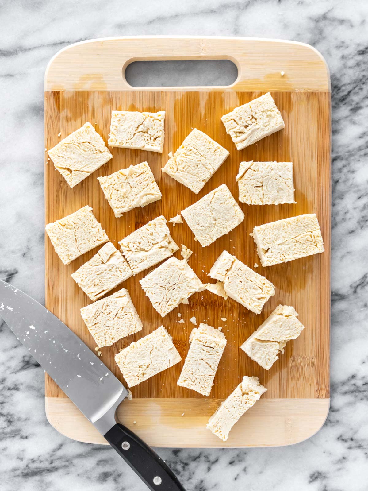 tofu cortado em pedaços em cima de uma tábua