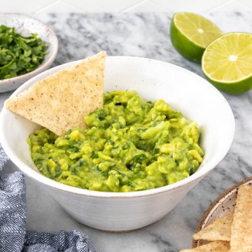 tortilla inserida em um bowl de guacamole