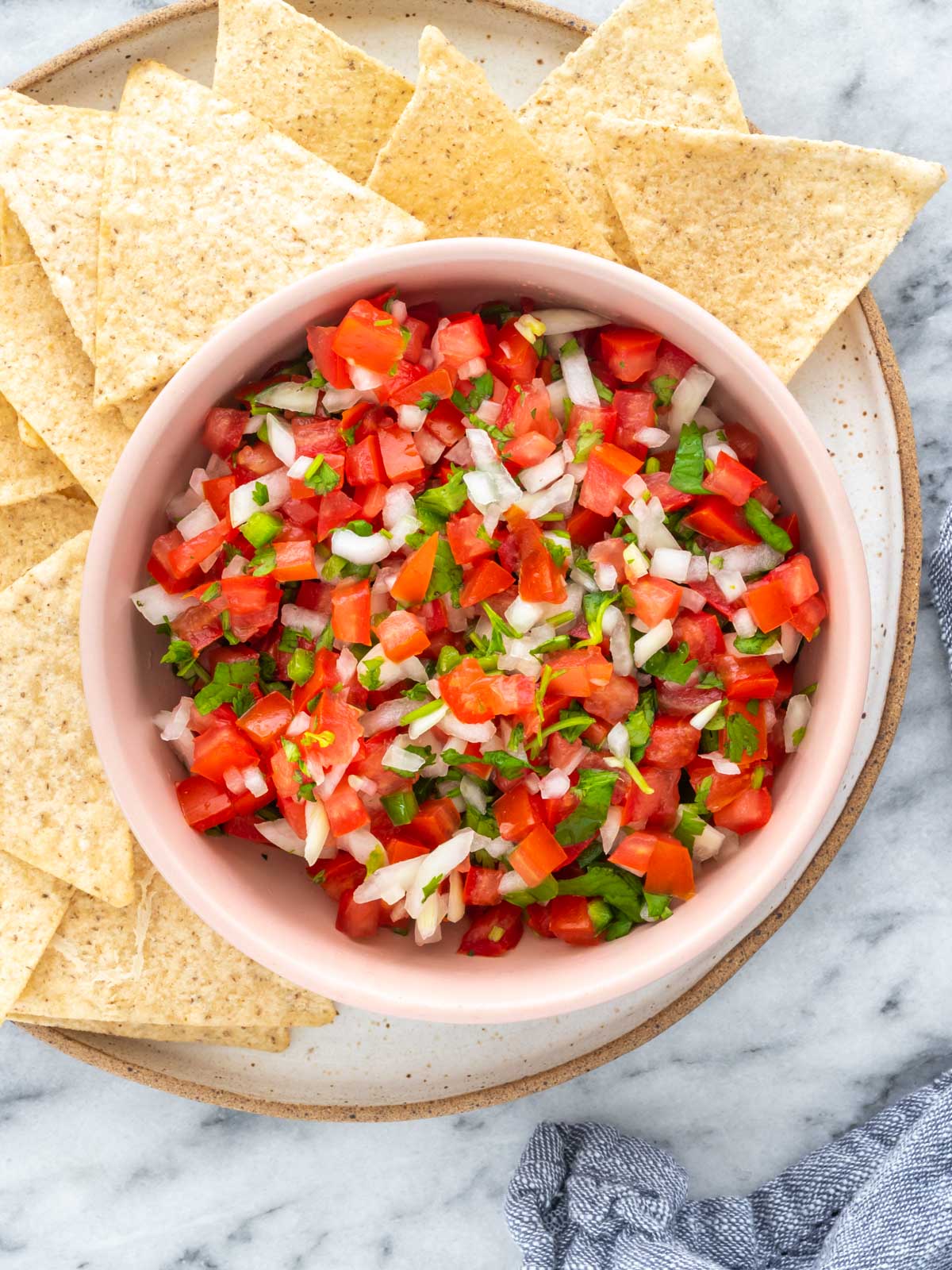 pote de pico de gallo em cima de um prato com tortillas