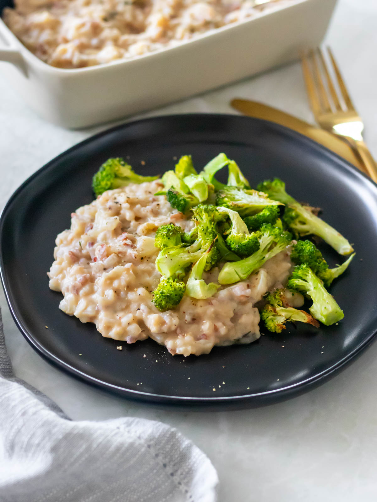 arroz cremoso servido em um prato com brócolis assado