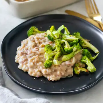 arroz cremoso com molho de feijão-branco servido em um prato com brócolis assado