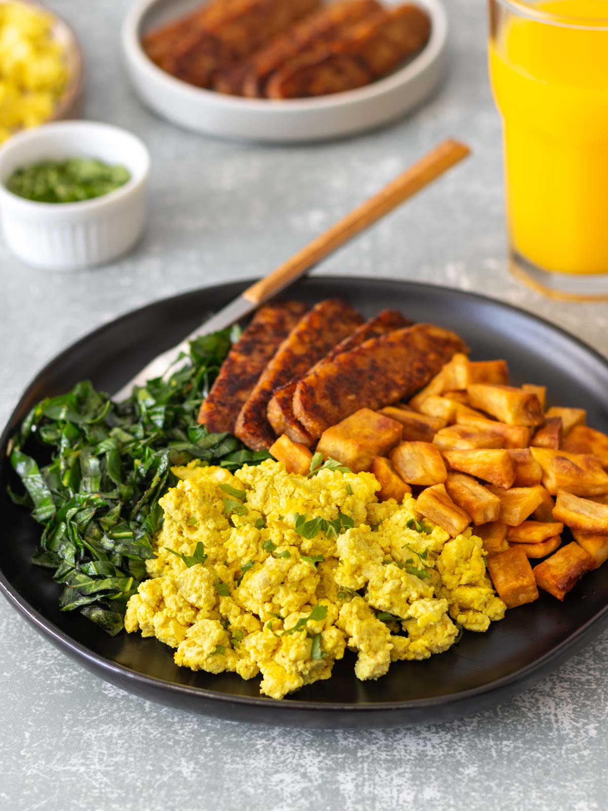 prato de tofu mexido cremoso servido com salsinha fresca picada, batata-doce assada, couve refogada e tempê grelhado