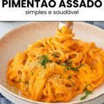 garfo sendo retirado de prato de macarrão envolvido com molho de pimentão vermelho assado, servido com parmesão vegano de castanhas e salsinha fresca picada