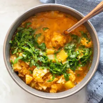 cumbuca de sopa de lentilha vermelha com legumes servida com salsinha fresca picada