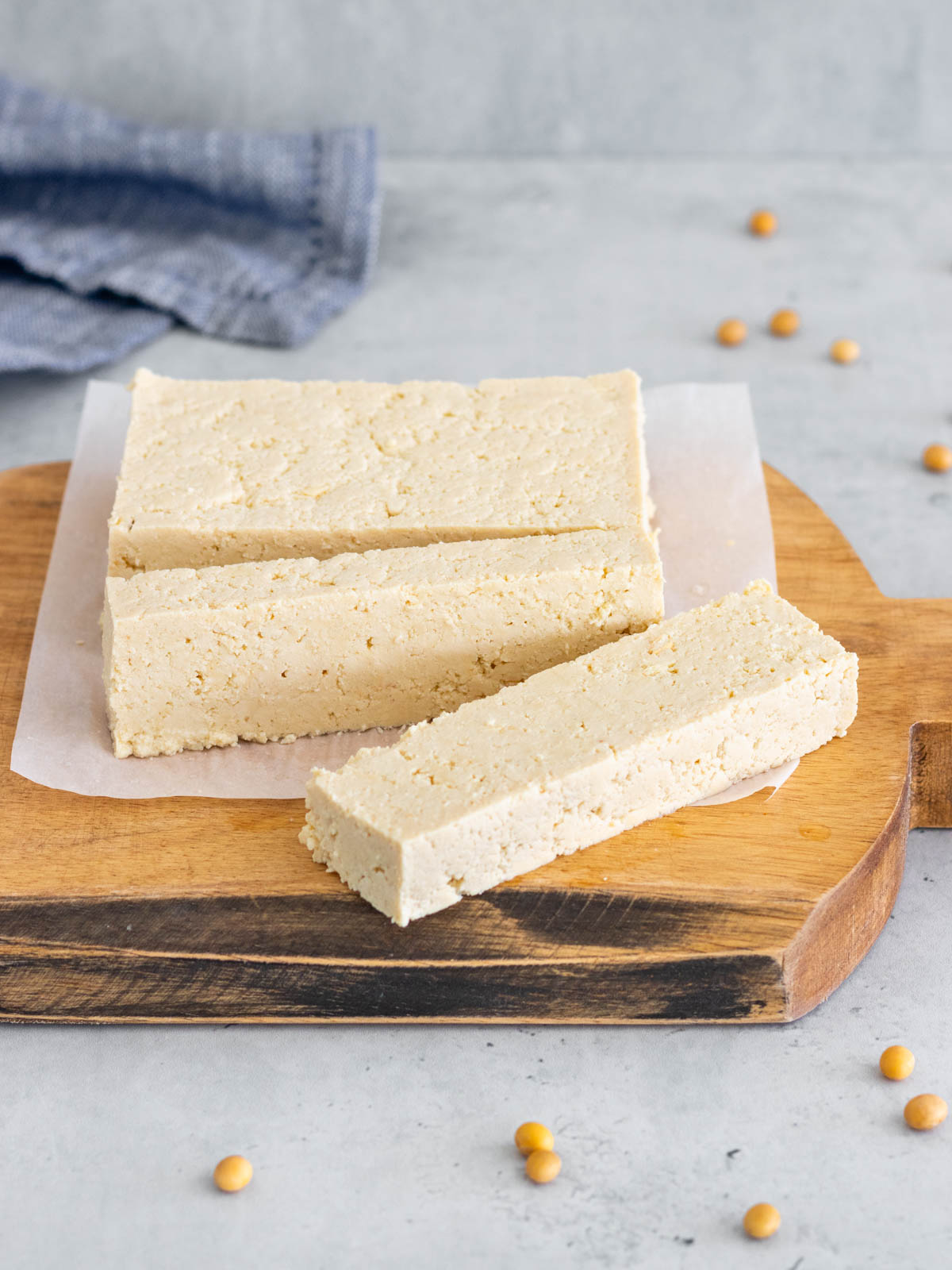 bloco de tofu caseiro cortado em cima de uma tábua, mostrando sua textura firme