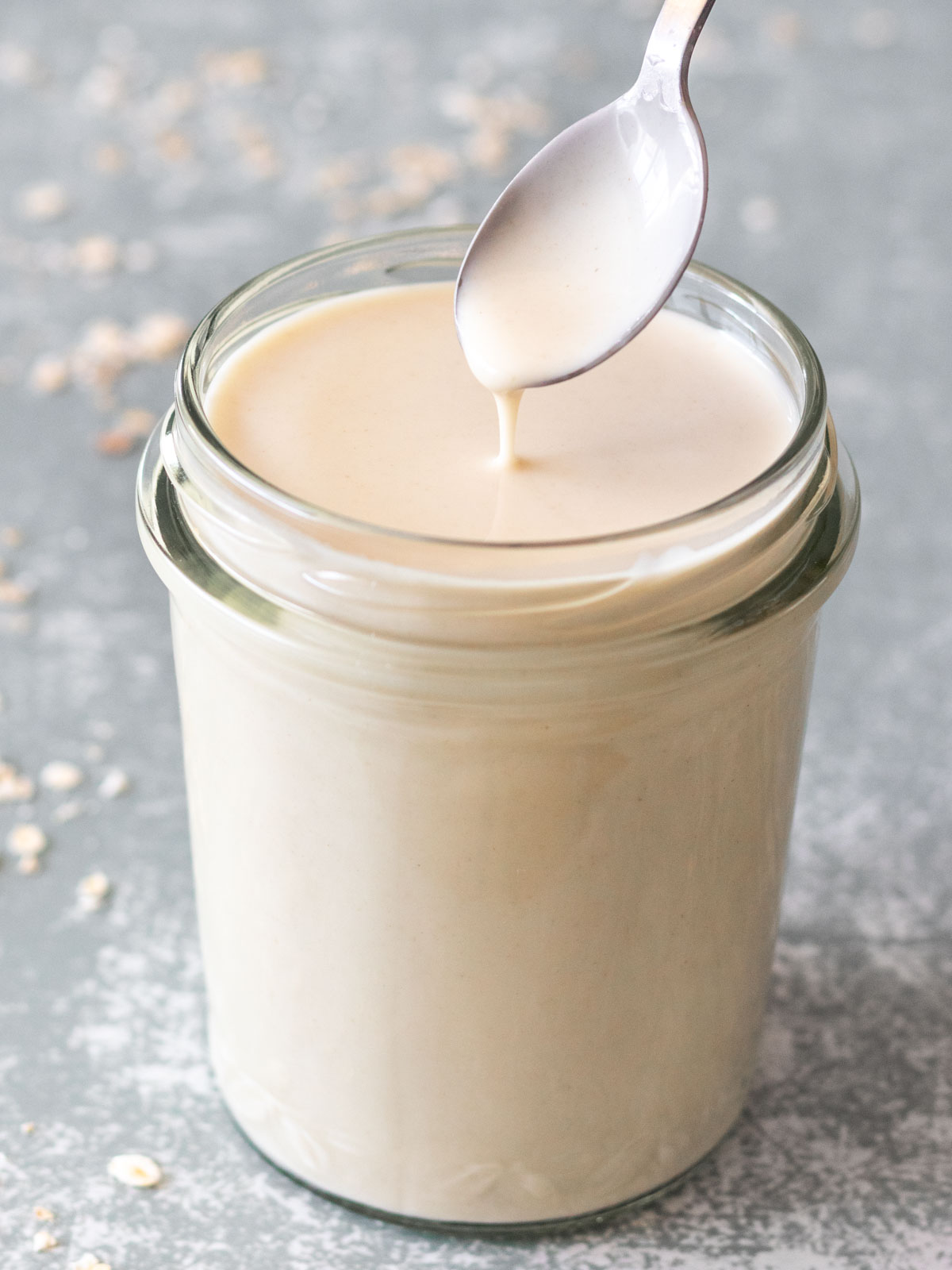 colher sendo retirada de pote de creme de leite de aveia