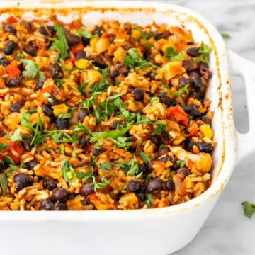 assado de arroz com feijão-preto e vegetais em uma travessa, misturado com coentro fresco picado